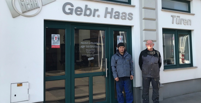 Herr Rezai mit seinem Ausbilder Herrn Perisic vor dem Eingang zur Firma Gebrüder Haas © Jugend am Werk
