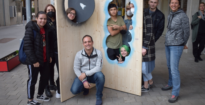 Lehrlinge und ihr Ausbilder vor zwei der gestalteten Türen © Jugend am Werk