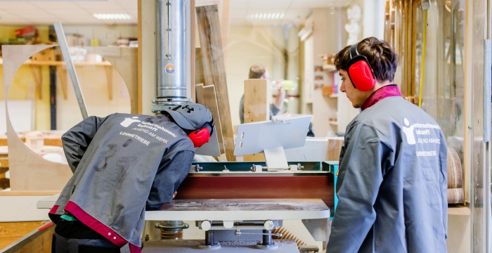 Lehrlinge bei einer Tischlermaschine © Kollektiv Fischka / fischka.com