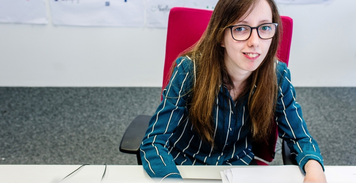 Mitarbeiterin im Büro beim Schreibtisch © Kollektiv Fischka / fischka.com