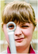 Junge Frau schaut durch einen Schraubschlüssel © kollektiv fischka/fischka.com
