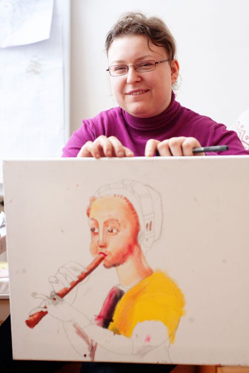Frau hält ein selbst gemaltes Bild in die Höhe © Kollektiv Fischka/fischka.com