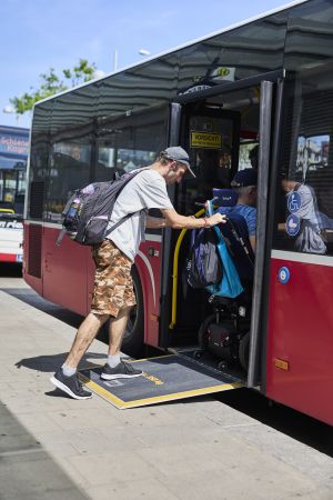 Ein Mobilitätsbegleiter schiebt eine Person im Rollstuhl in den Bus © Kollektiv Fischka/fischka.com Ein Mobilitätsbegleiter schiebt eine Person im Rollstuhl in den Bus © Kollektiv Fischka/fischka.com