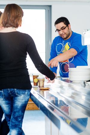 Mann kassiert Geld für zwei Kaffees im Cafe Genusswerk © Kollektiv Fischka/fischka.com