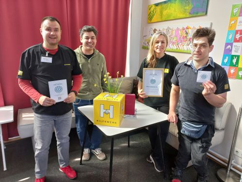 Gruppenfoto mit Urkunde Partnerbetrieb 2026, Wiener Hilfswerk Club 21 © Jugend am Werk