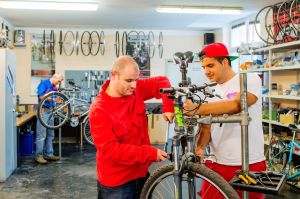 Zwei junge Männer arbeiten an einem Fahrrad am Standort Altmannsdorf © Kollektiv Fischka/fischka.com